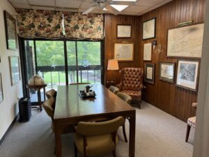 Conference room with leather wingback chairs and globe at Kendall Page Attorney office