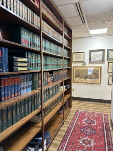 Law library shelves with legal reference books and historical Durham map at Kendall Page office